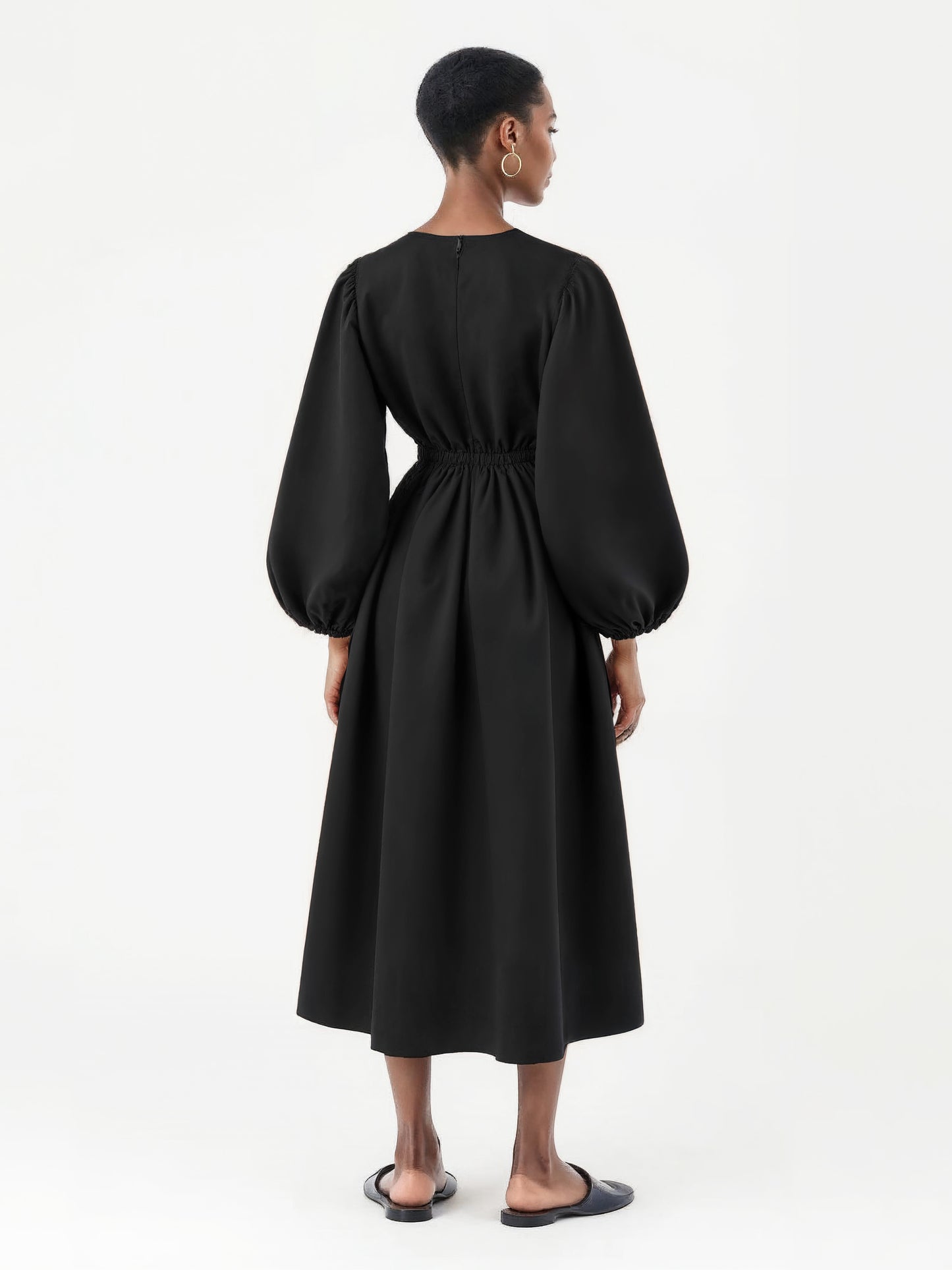 Black dress with voluminous balloon sleeves and a flared mid-calf silhouette.
